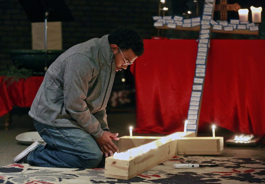 A student lights a candle inside a cross during a prayer vigil that was held on Monday, Nov. 28, 2016 at Jacobs Porch, the Lutheran Campus Ministry at Ohio State University, after a man attacked pedestrians with a car and then a knife, injuring nine people. (Barbara J. Perenic/Columbus Dispatch/TNS)