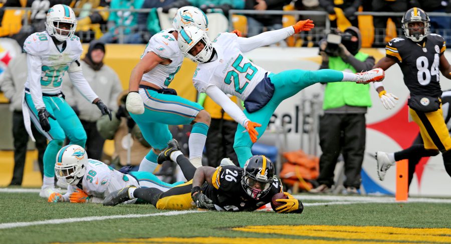 Miami Dolphins Xavien Howard (25) loses his balance as Pittsburgh Steelers LeVeon Bell takes the ball to the one yard line to help him score on the drive in the second quarter in the NFL Wild Card Playoffs on Sunday, Jan. 8, 2017 at Heinz Stadium in Pittsburgh, Pa. (Charles Trainor Jr./Miami Herald/TNS)