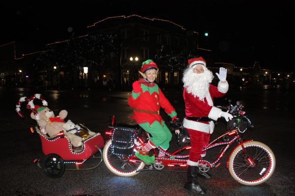 Sue and Patrick Wemmer dressed as an elf and Santa Claus on their tandem bike decorated for Christmas. This is the Wemmers third time dressing up for Christmas and peddling around the Candlelight Walk. Photo by Riley Hunt.