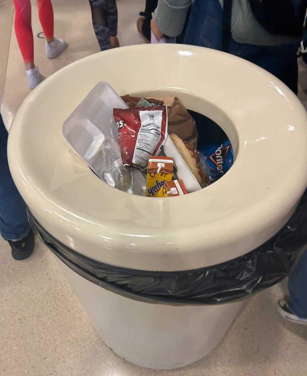 Trash cans at WHS overflow with trash every day. Food that could be saved is often thrown into them, causing them to overflow and leading to more food waste. Photo by Emma Lynn.