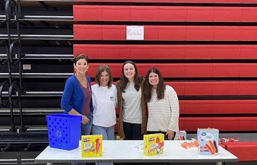 Pictured here are (left to right) Kelly Rapp, Nikki Farson, Carly DiPaolo, and Lauren Ross. At one of the first events held by PBIS where they passed out sweet treats to students with no tardies. Photo by Larkin Tackkett. 