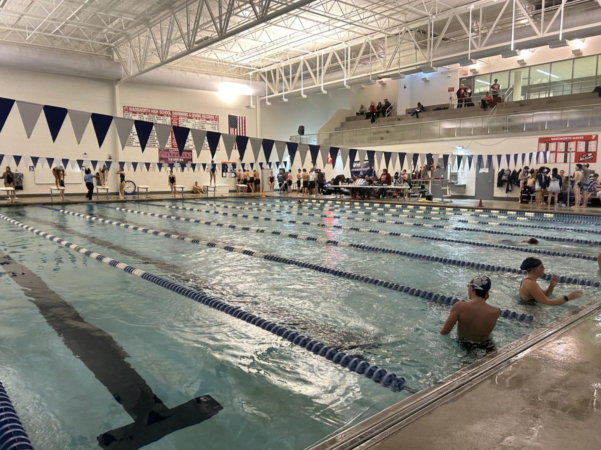 The visiting teams, Hudson and Twinsburg, warm up before the meet. Both Wadsworth teams fell to Hudson, but the Wadsworth girls team beat Twinsburg. Photo by Lizzy Edwards. 