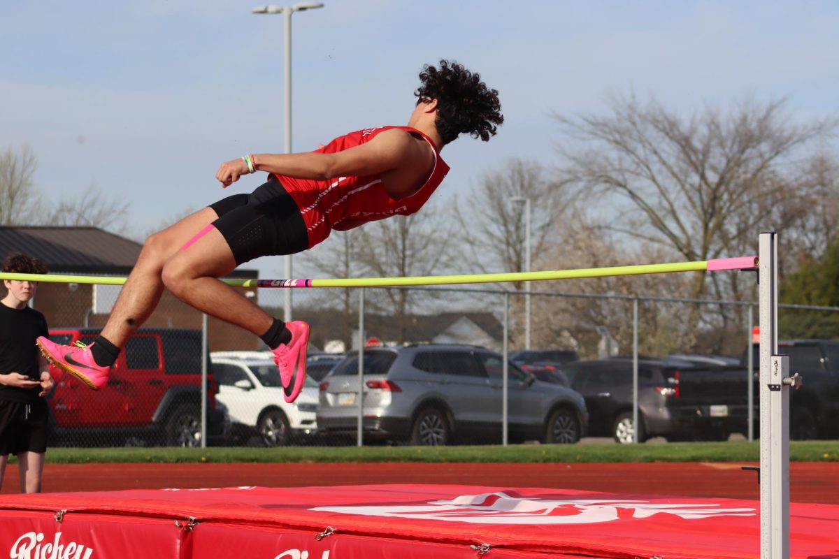 Sophomore Luis Caraballo jumping into the high jump pit.  This ended up being Caraballo’s final jump for the meet. Photo by Corrine Hinkle.
