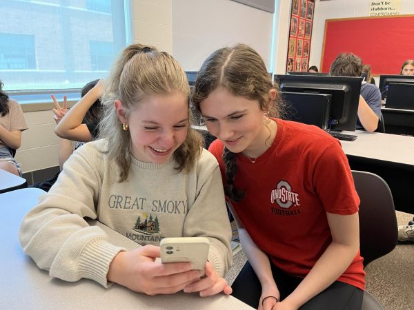 Two students look at their phone during class. Currently, phone usage in classes is up to teachers. Photo by Alex Banks. 