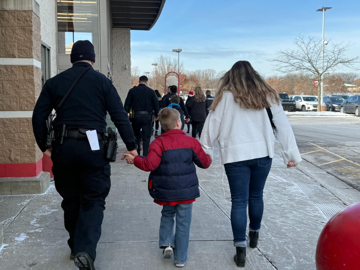 Officer Rospert and his wife chaperone and guide a kid to Target, ready to go on a shopping spree. The children got to ride in different first responder’s vehicles to get from the high school to Target, such as ambulances with their convoy lights on. Photo courtesy of Officer Smith.
