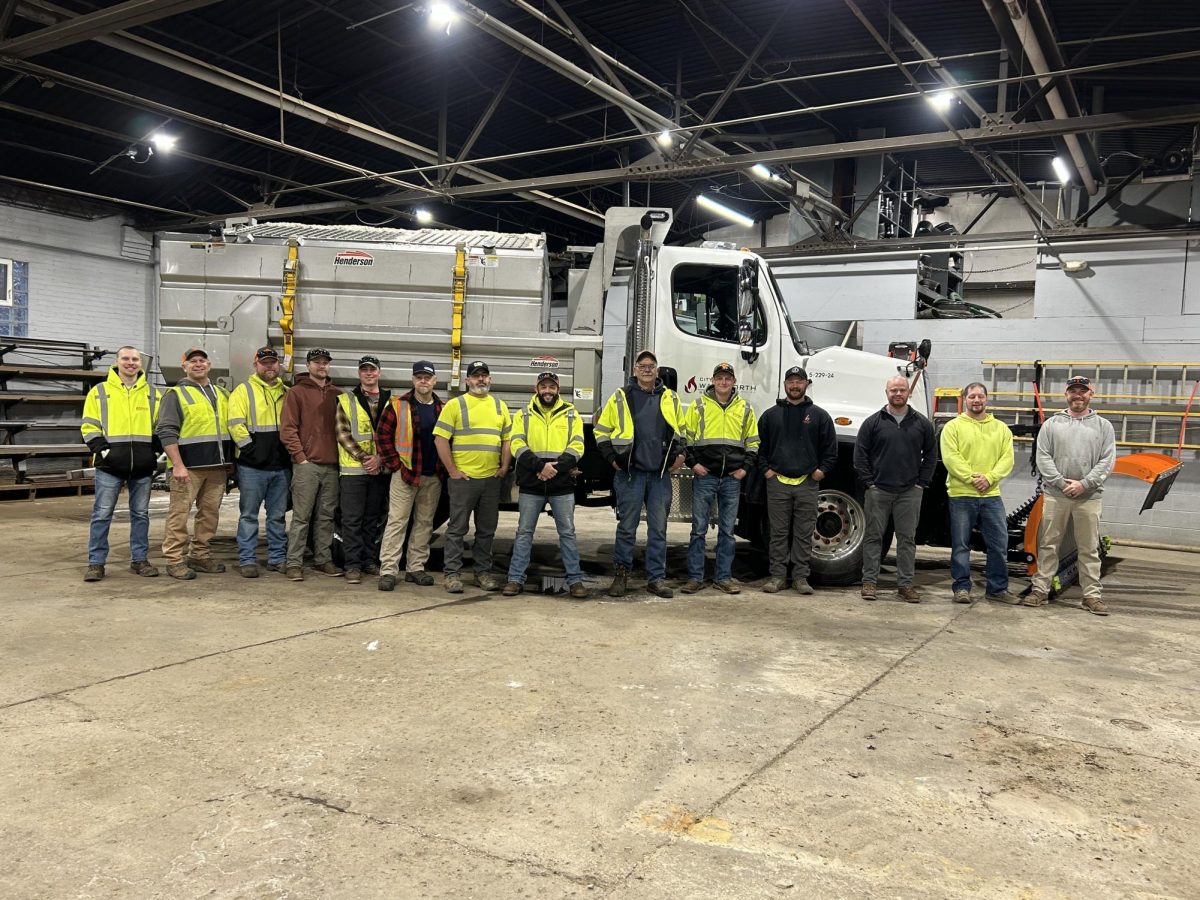 Pictured from left to right is Nick Eggeman, Steve Polsfuss, Kevin Taylor, Bryan Canterbury, Max Brammer, Jay Eckroth, Josh Brown, Dan Cadle, Jerry Whitehead, Dylan Hicks, Garrett Cameron, Bryan Shriver, Erik Hornung, Joe Light. The streets department crew smiles for a picture in front of one of their plow trucks they use during winter. Photo courtesy of Kathy Stugmeyer.