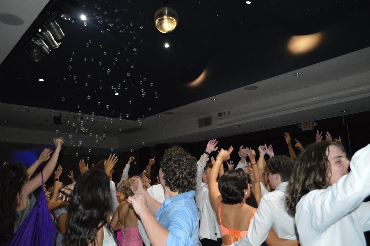 Students dance to the DJ's music, as bubbles are floating around. There were bubble machines in the ceiling that surprised students.