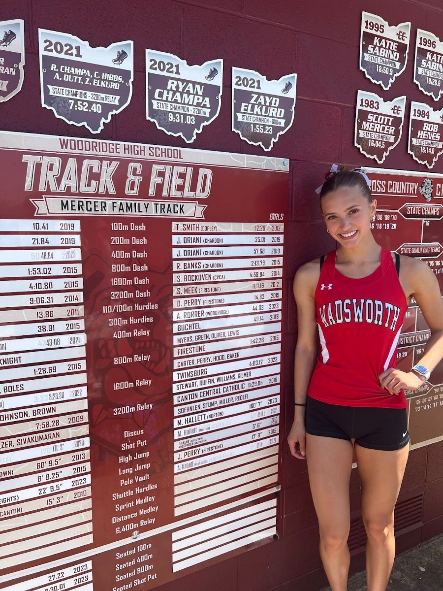 Hailey Otradovec stands next to the record board on the Woodridge track. She ran a personal record and stadium record at 57.11.