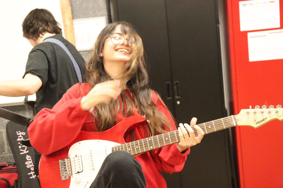 Senior Natalie Lyren plays her guitar at a club meeting. The other members were playing the song that was going to be practiced during this meet.