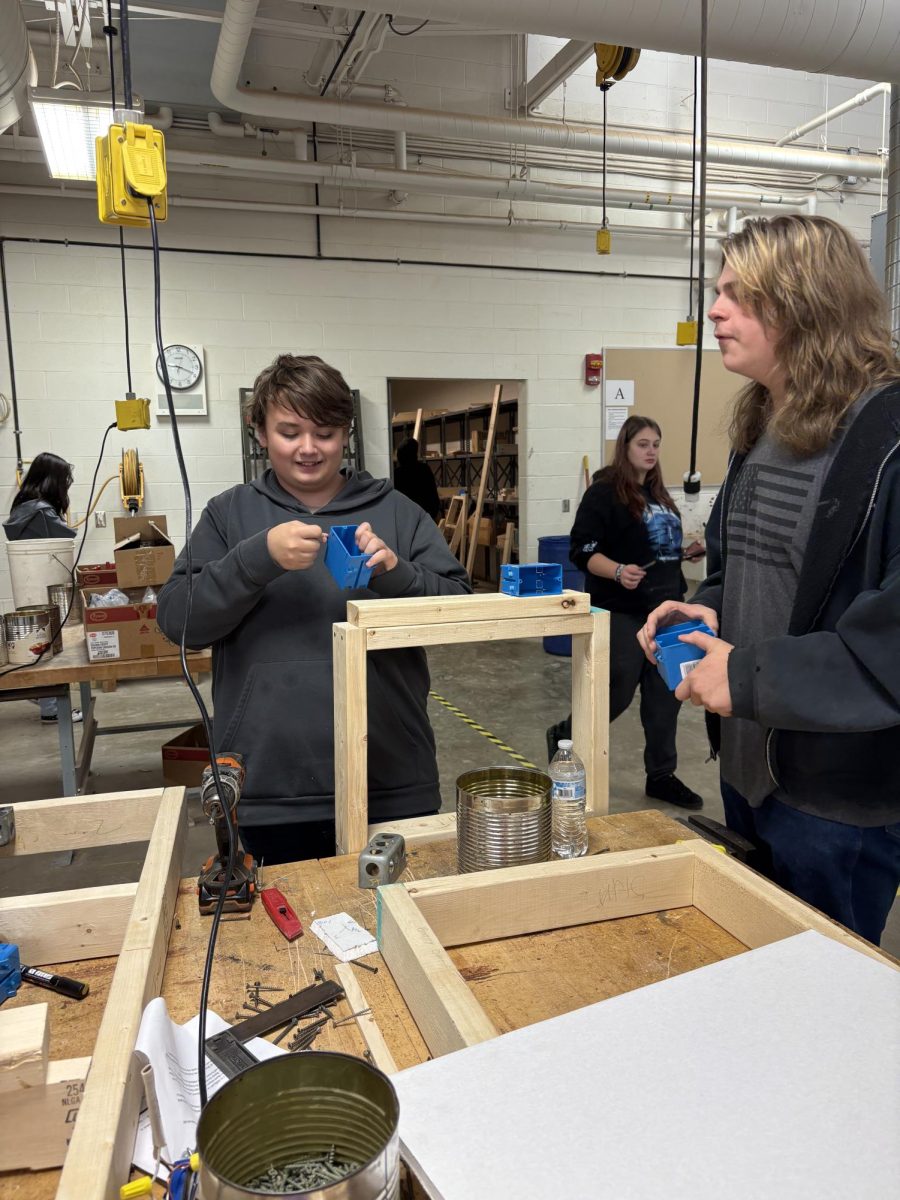 Jackson Thomas(10) and Cameron Hughes(12) work on a wall framing model in class. This model is an intro to framing components, drywall, and basic electrical. These are all things that can help you in the home. Photo by Jack Blubaugh.