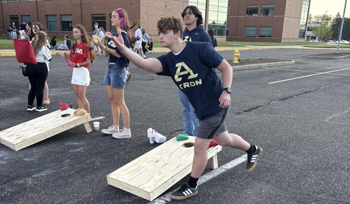 Aiden McAnalley tosses a bean bag while playing cornhole with other seniors. McAnalley is going to college at the University of Akron. 